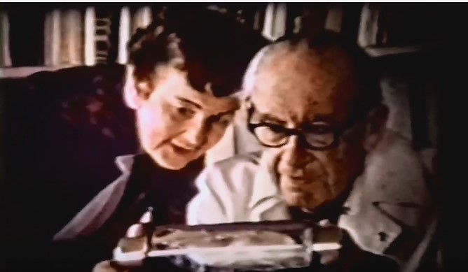 An older man and woman examining a type writer.
